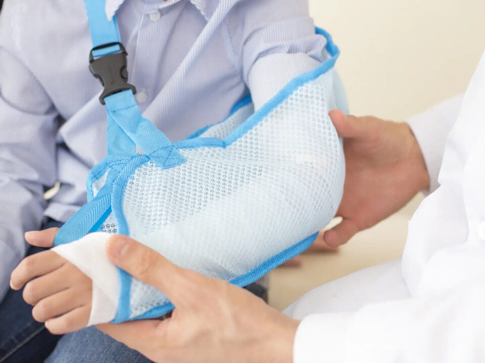 Lekarz badający złamaną rękę dziecka
